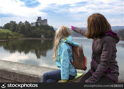 Beautiful girls sit and look at the castle niedzica, Poland