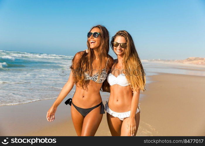 Beautiful girls walking and having fun on the beach