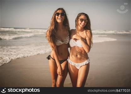 Beautiful girls walking and having fun on the beach