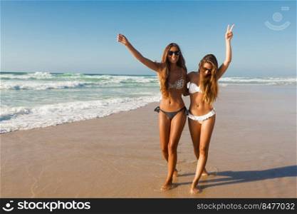 Beautiful girls walking and having fun on the beach