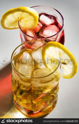 Beautiful glasses with a cocktail, a lemon and an ice