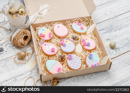 Beautiful glazed Easter cookies on wooden table - eggs in the box. Beautiful glazed Easter cookies