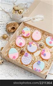 Beautiful glazed Easter cookies on wooden table - eggs in the box. Beautiful glazed Easter cookies