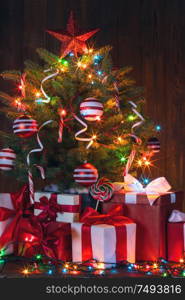 Beautiful glowing decorated Christmas Tree and many gifts. Christmas Tree and gifts