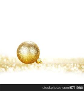 Beautiful golden christmas ball on abstract glitter background close-up