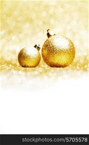 Beautiful golden christmas balls on abstract glitter background close-up
