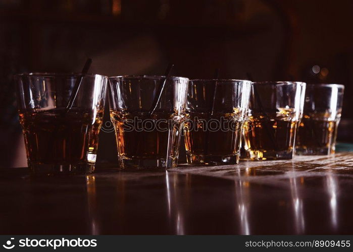 beautiful, golden row of cocktails on the bar