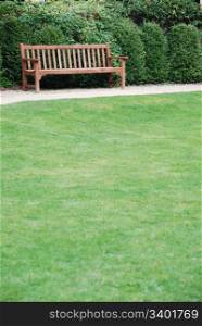 beautiful green grass view with a empty wooden bench