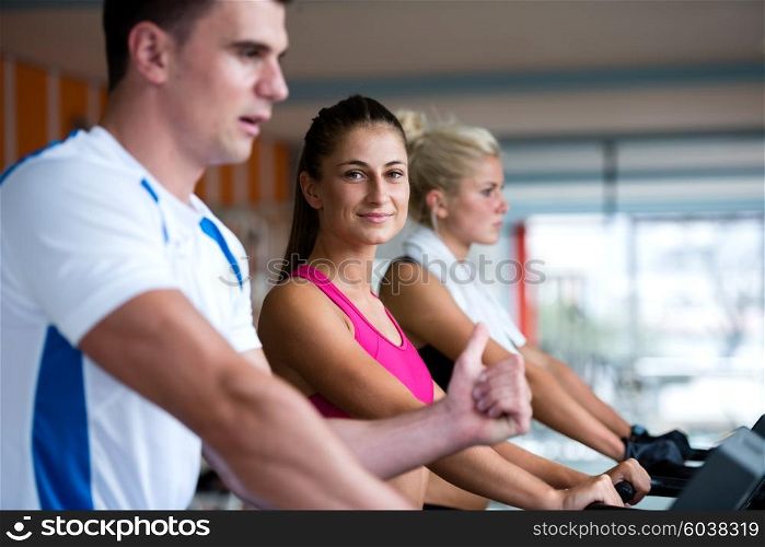 Beautiful group of young women friends exercising on a treadmill at the bright modern gym