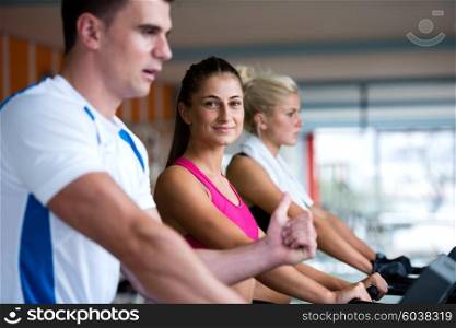 Beautiful group of young women friends exercising on a treadmill at the bright modern gym