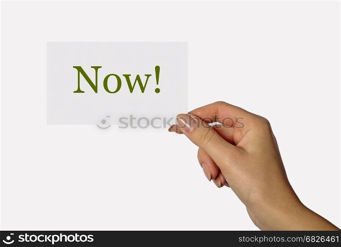 Beautiful hand of a young girl holding a card on a white background with the inscription Now!