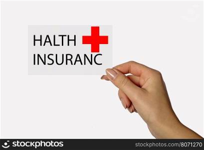 Beautiful hand of a young girl holding a card on a white background with the inscription HALTH INSURANCE