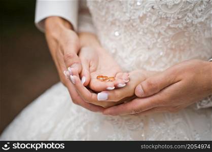 Beautiful hands of newlyweds embrace each other holding wedding rings.. Hugs of newlyweds with wedding rings 2780.