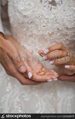 Beautiful hands of newlyweds embrace each other holding wedding rings.. Hugs of newlyweds with wedding rings 2782.