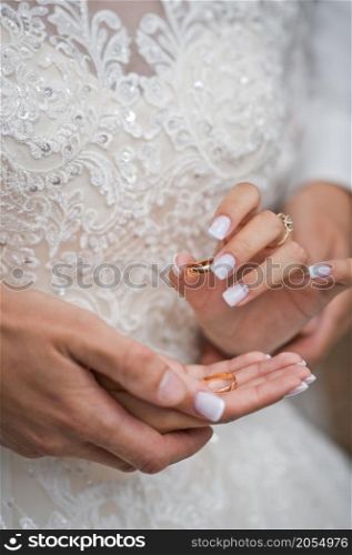 Beautiful hands of newlyweds embrace each other holding wedding rings.. Hugs of newlyweds with wedding rings 2783.