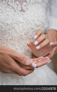 Beautiful hands of newlyweds embrace each other holding wedding rings.. Hugs of newlyweds with wedding rings 2783.