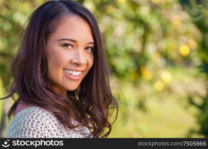 Beautiful happy Asian Eurasian Chinese biracial young woman or girl outdoor smiling portrait in summer sunshine
