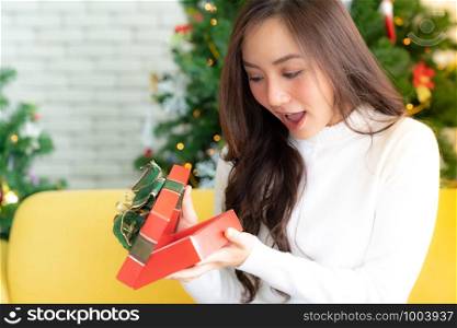 beautiful happy asian girl opening christmas present gift box for Christmas holiday season greeting.