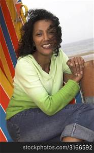 Beautiful happy black woman sitting in a beachchair