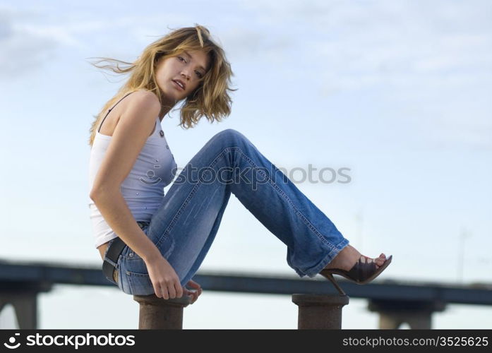 beautiful happy blond woman near a river in jeans