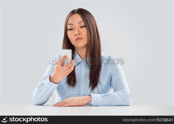 Beautiful happy business woman reading a text message sitting at her desk