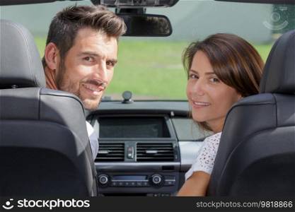 beautiful happy couple of travelers driving car
