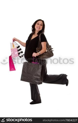 Beautiful happy exciting smiling Caucasian pregnant brunette woman holding shopping bags while walking and having her leg up, isolated