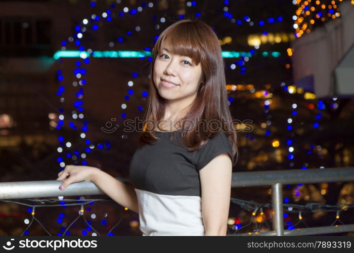 Beautiful happy Japanese female with colorful lights in background