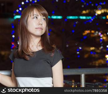 Beautiful happy Japanese female with colorful lights in background