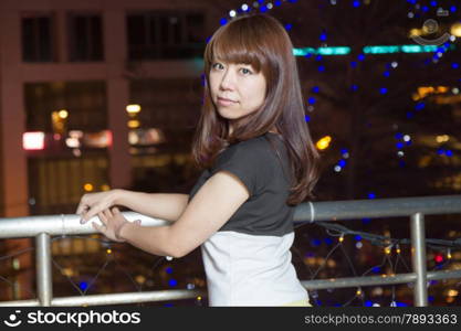 Beautiful happy Japanese female with colorful lights in background