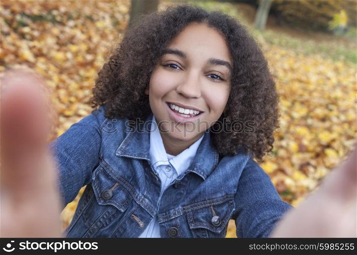 Beautiful happy mixed race African American girl teenager female child smiling with perfect teeth taking selfie photograph