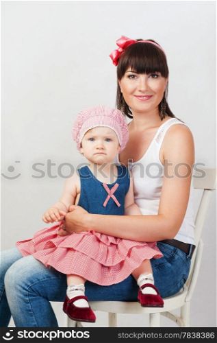 Beautiful happy mother with baby daughter on white background