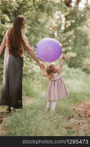 Beautiful happy mother with daughter having fun in green field holding balloons. mother and daughter with balloons. Mom, kid, mother.. mother and daughter with balloons. Beautiful happy mother with daughter having fun in green field holding balloons. Mom, kid, mother.