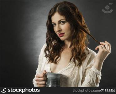 Beautiful happy redhead woman drinking coffee over dark background.