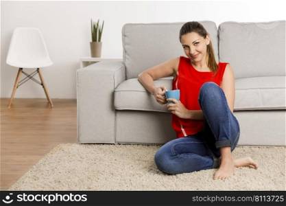 Beautiful happy woman at home drinking coffee