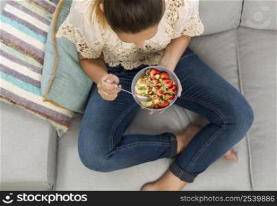 Beautiful happy woman at home eating a healthy bowl