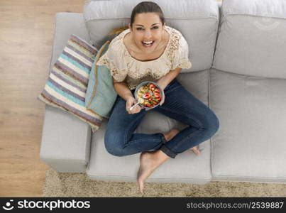 Beautiful happy woman at home eating a healthy bowl