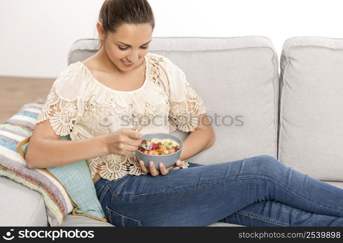 Beautiful happy woman at home eating a healthy bowl