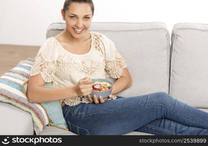 Beautiful happy woman at home eating a healthy bowl