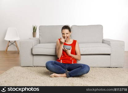 Beautiful happy woman at home eating a healthy bowl 