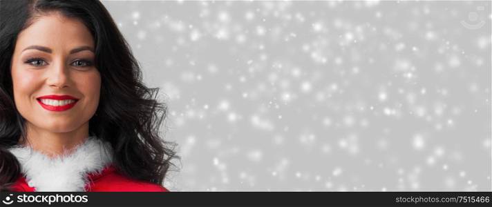 Beautiful happy woman in Santa Claus clothes on glowing lights bokeh background. Woman in Santa Claus clothes