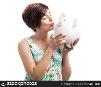 Beautiful happy woman kiising a piggy bank, isolated over a white background