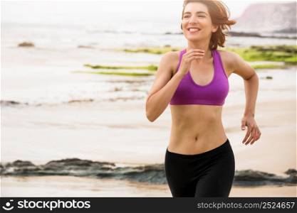 Beautiful happy woman running on the beach