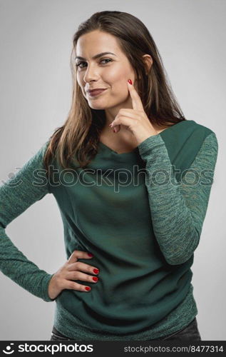 Beautiful happy woman smiling over a gray background