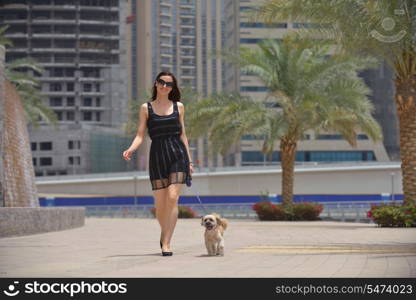 beautiful happy young woman in black dress with cute small dog puppy have fun on street