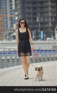 beautiful happy young woman in black dress with cute small dog puppy have fun on street