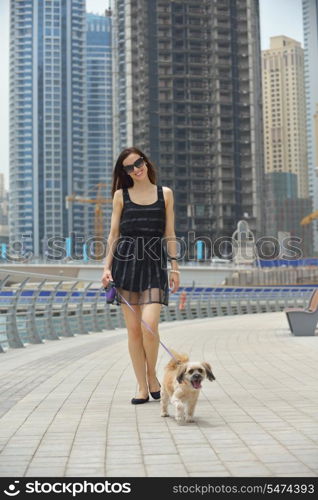 beautiful happy young woman in black dress with cute small dog puppy have fun on street