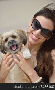 beautiful happy young woman in black dress with cute small dog puppy have fun on street