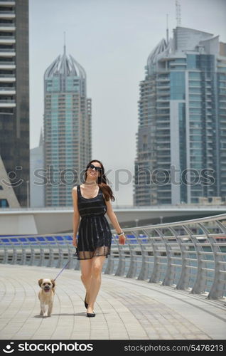 beautiful happy young woman in black dress with cute small dog puppy have fun on street