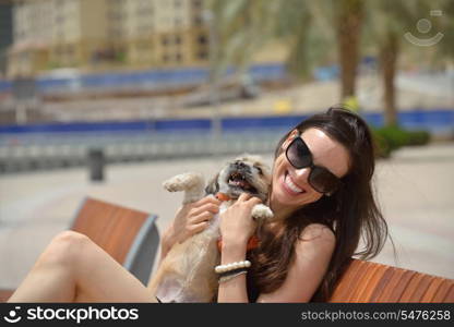 beautiful happy young woman in black dress with cute small dog puppy have fun on street